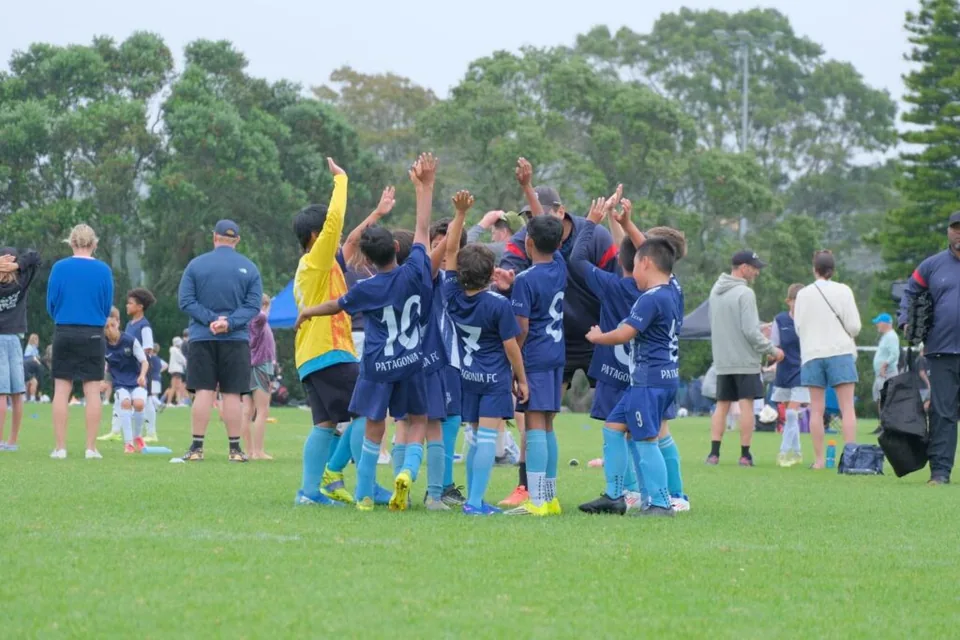 Patagonia FC youth team huddles with a coach before a match